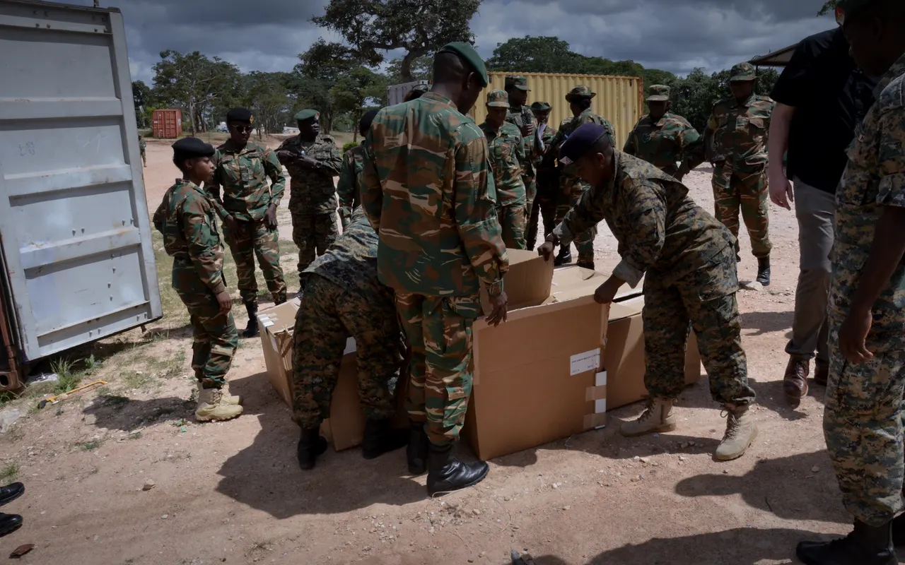 Soldiers unpacking cartons of Aspetto-supplied equipment from a shipping container at a delivery in Zambia